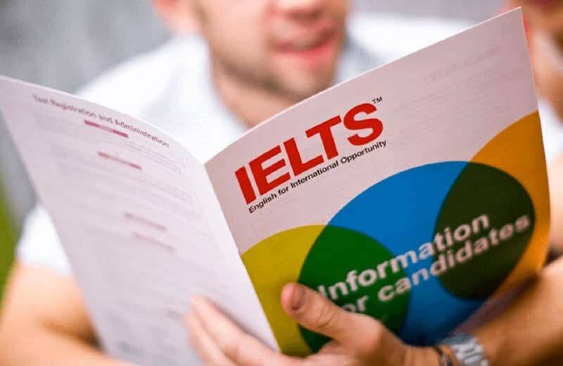 Students reading from IELTS book 